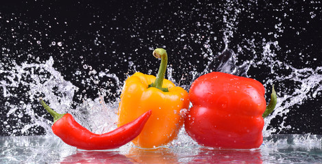 drops of water fall on the red and yellow pepper, splash - Powered by Adobe