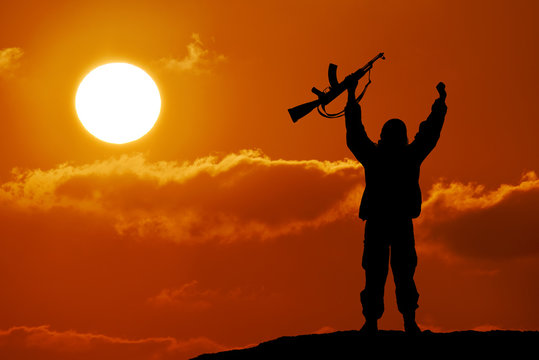 Silhouette of military soldier officer with weapons at sunset