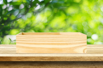 Wooden storage box on table over blur tree background