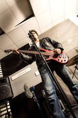 Fototapeta na wymiar Rock singer playing bass in the rehearsal Studio