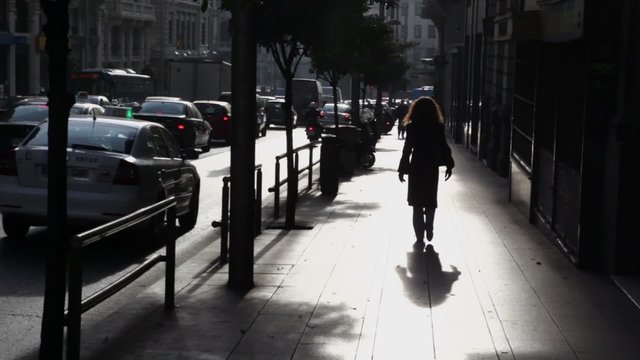 Woman walk by street with traffic in Madrid