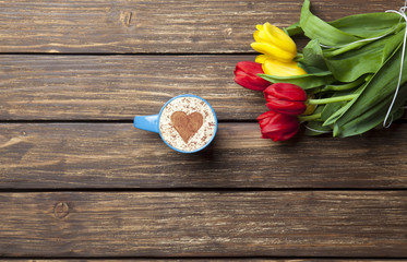 cappuccino with heart shape and bouquet of tulips