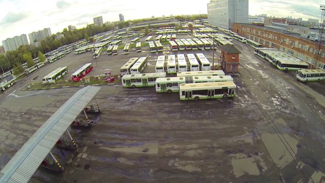 Top view of bus parking lot with gas station, ascending view