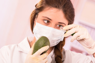 young beautiful woman biologist experimenting with avocado