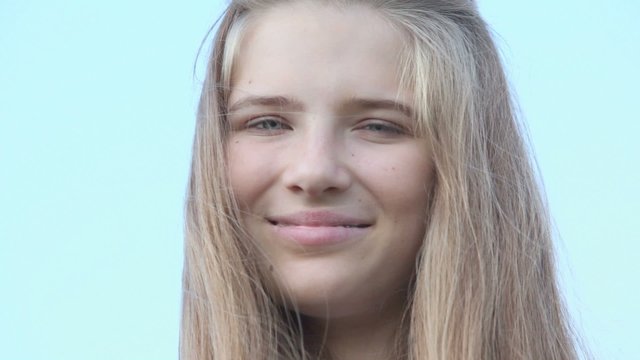 Young girl with brackets on teeth watch and smile,  closeup view at summer day 