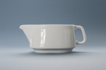 White gravy boat on a blue background..