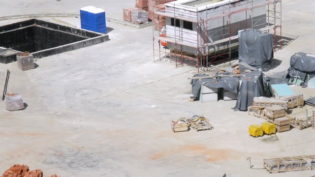 Worker go on building site of housing estate in sunny weather