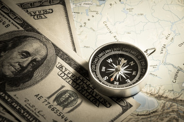 Compass with money on map.