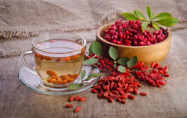 goji fresh antioxidant tea in glass cup and barberries in wooden