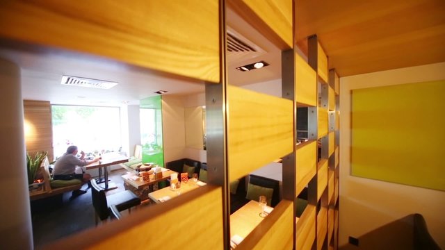 Wooden partition in hall of cozy cafe with modern interior