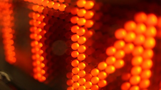 Running line on digital screen with red letters, zoom