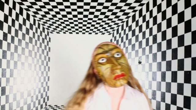 Young girl in mask sways in black and white square room 