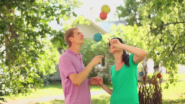 couple touch decorative balls at summer day