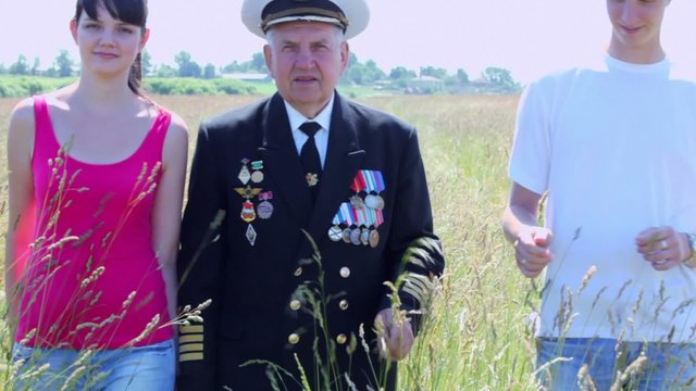 Grandfather in marine uniform approach with couple in field