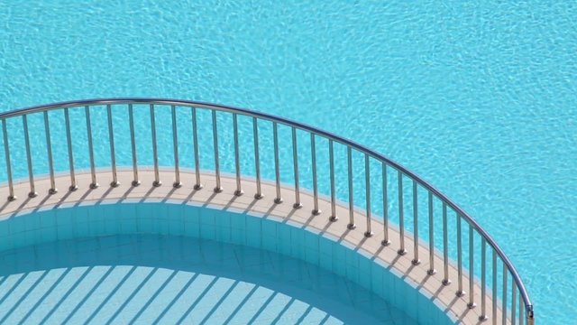 Two swimming pools and separating ledge with steel handrails