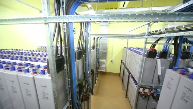 Aisle between racks with accumulators of backup power system