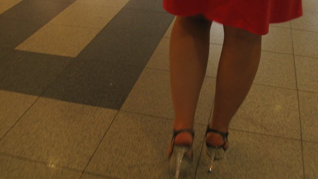 Woman legs in short red dress walking, timelapse