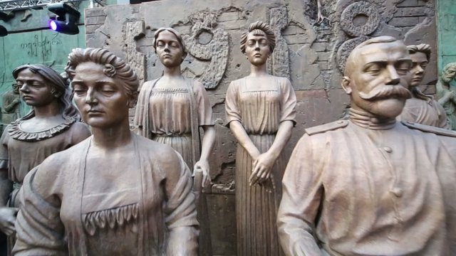 Statues of man and woman sitting with statues of women