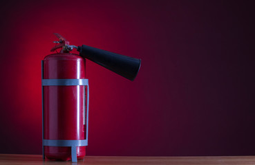 Fire extinguisher on a red background.