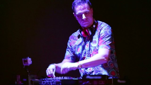 DJ at his workplace in nightclub mixes records with equipment