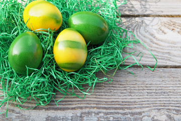 Osternest mit gelb und grün gefärbten Eiern