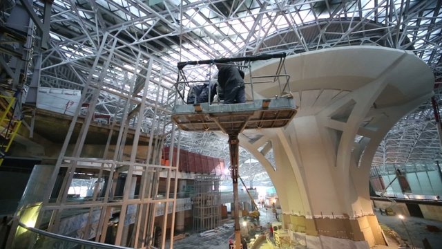 Worker in telescopic platform on construction of new terminal