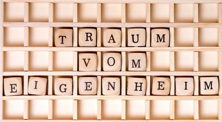 Holzwürfel und die Worte Traum vom Eigenheim