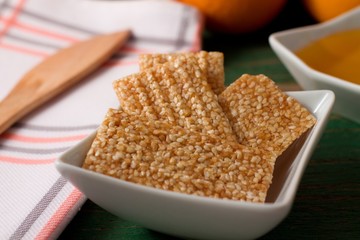 Sesame wafers with honey in white bowl