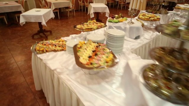Covered tables with different snacks in restaurant of hotel.
