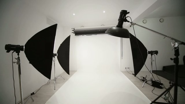Photographic equipment and a white backdrop in studio.