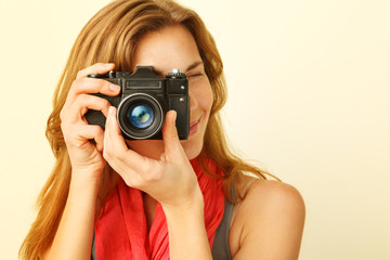 Young redhead woman looking through viewfinder with an old 35mm