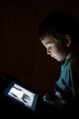 kid with tablet in the dark