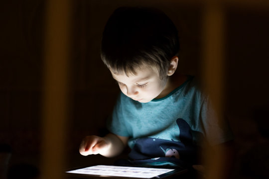 kid with tablet in the dark