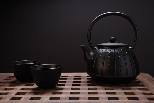 Image of traditional eastern teapot and teacups on wooden desk