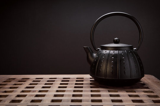 Image of traditional eastern teapot on wooden desk