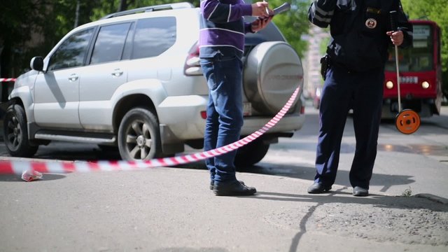 Policeman writes report of serious car accident 