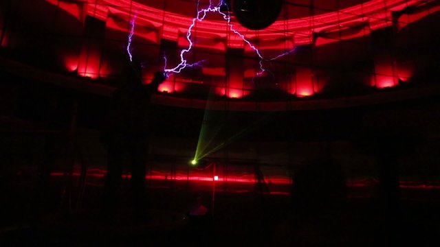 Two men in mail play with artificial lightning at presentation