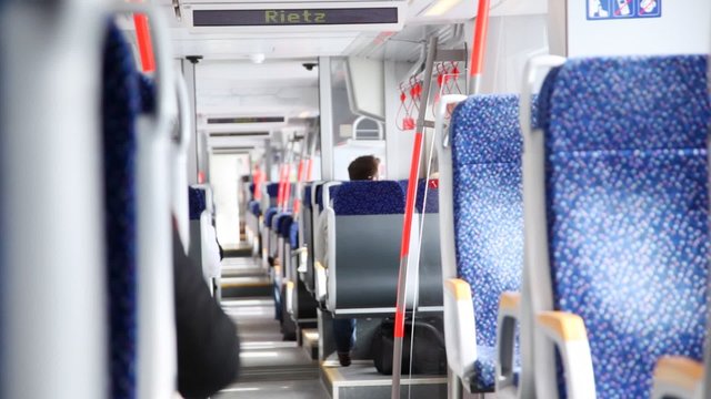 Dark blue chairs with yellow armrests stand in carriage of train