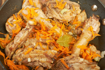 Fried chicken in the pan on a wooden background