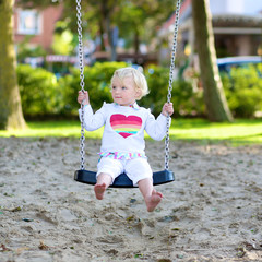 Happy preschooler girl playing in summer park