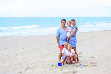 Happy family with kids enjoying beach vacations