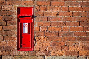 vintage red mailbox build in a brick wall