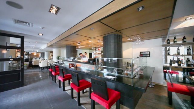 Bartenders at bar counter in eastern restaurant, waiter comes and passes by