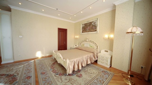 Beautiful clear bedroom with armchairs, table and lamps.