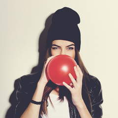Beautiful hipster teenage girl with red balloon