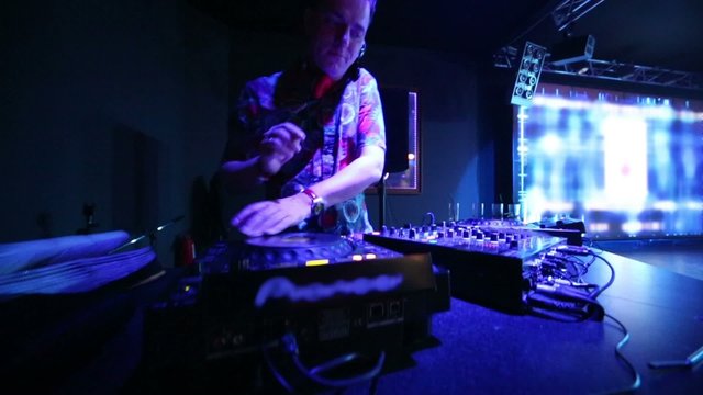 DJ at his workplace in nightclub, camera moves up and down