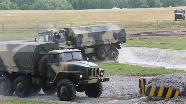 The military cars Ural-5323 and Ural-4320 overcome obstacles