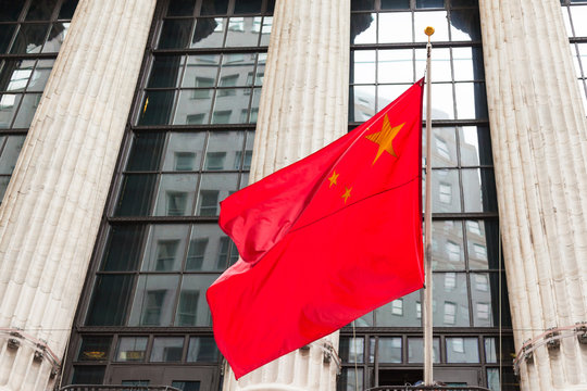 Fototapeta Chinese flag floating in front of a goverment building