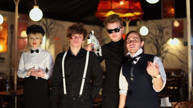 Four young members of rock band perform in cafe