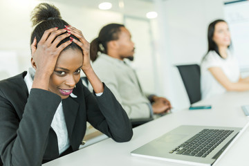 Young stressed businesswoman battling with a headache